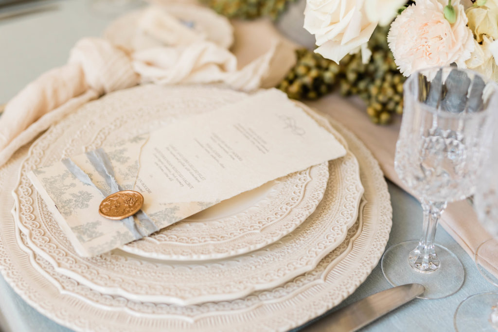 vintage wedding decor for reception table with menu on top of cream plates 