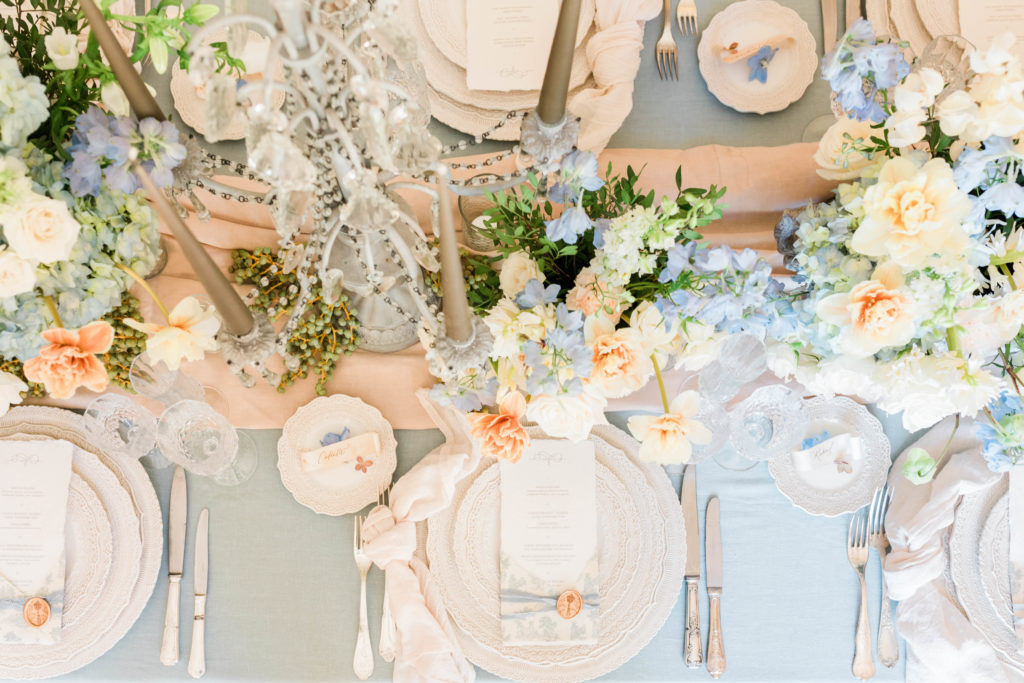blush pink, dusty blue, and greenery filled tablescape at destination wedding in Paris