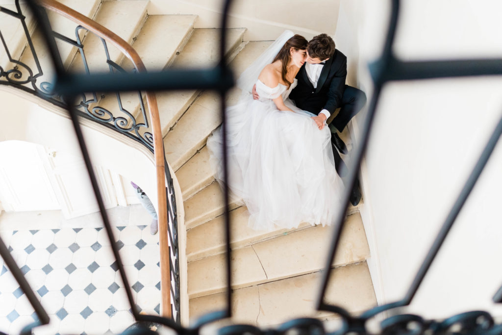 bride and groom sitting in a stair well together 