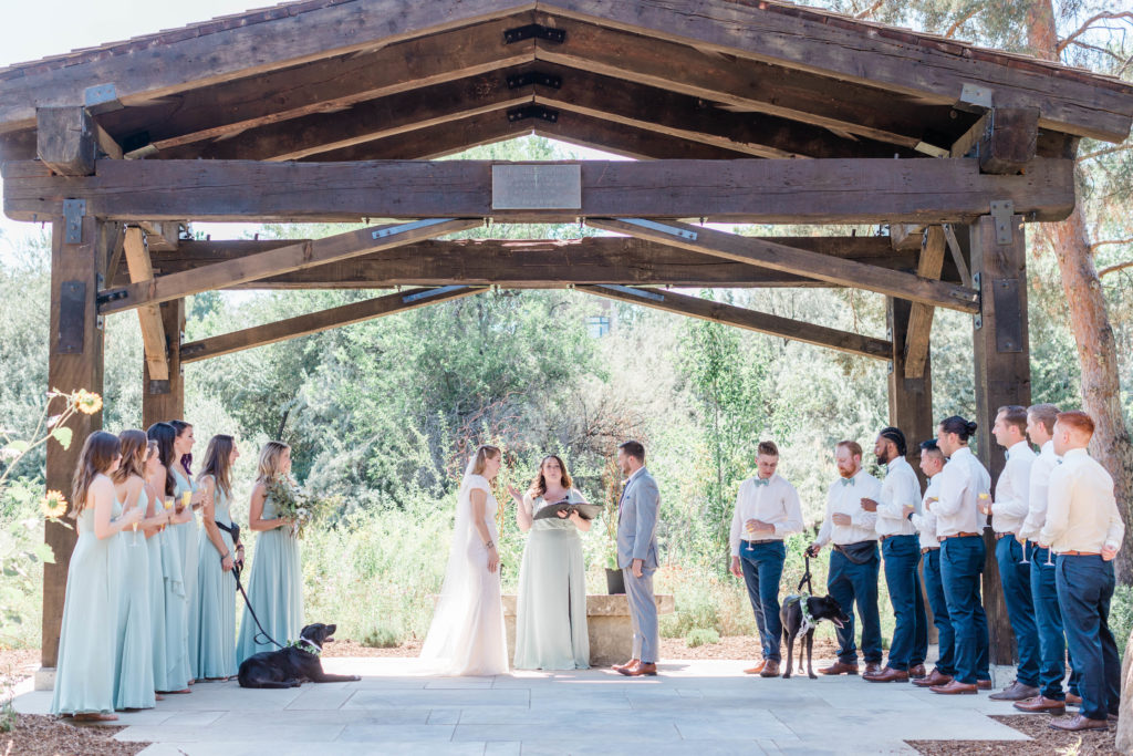 Boise outdoor wedding ceremony under a pergola captured by Boise wedding photographer 
