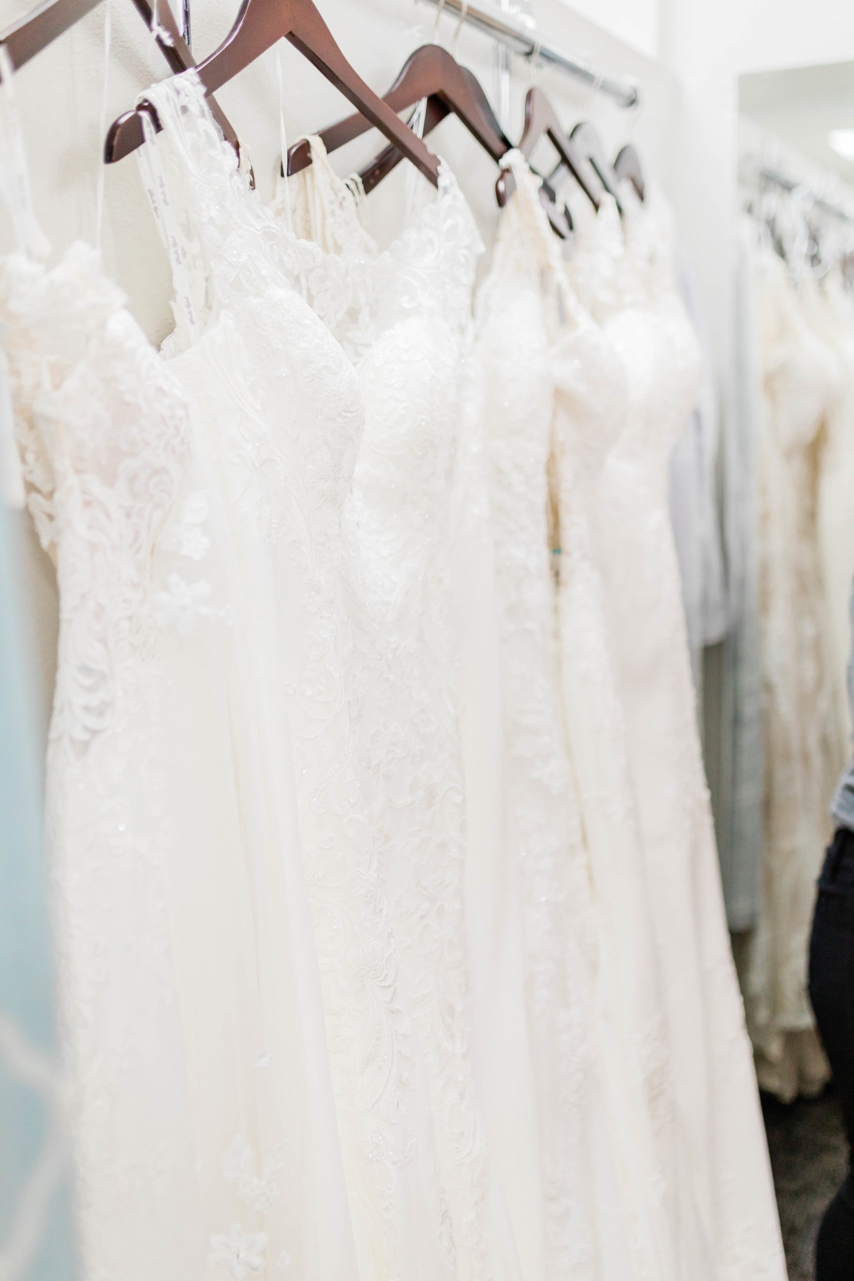 detail shot of lace wedding dresses hanging on the rack at Boise bridal shop photographed by Boise wedding photographer