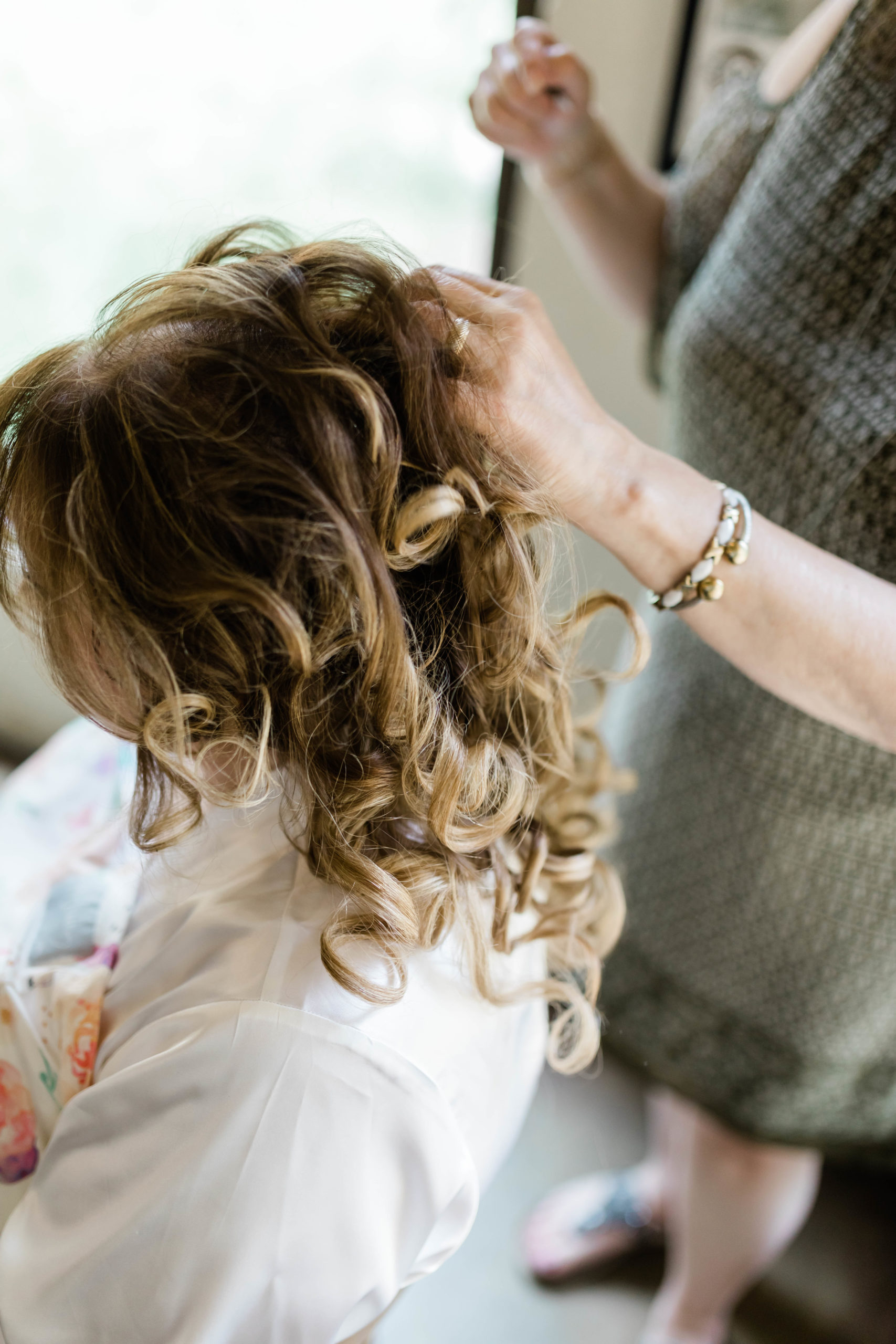 bride getting hair done before wedding