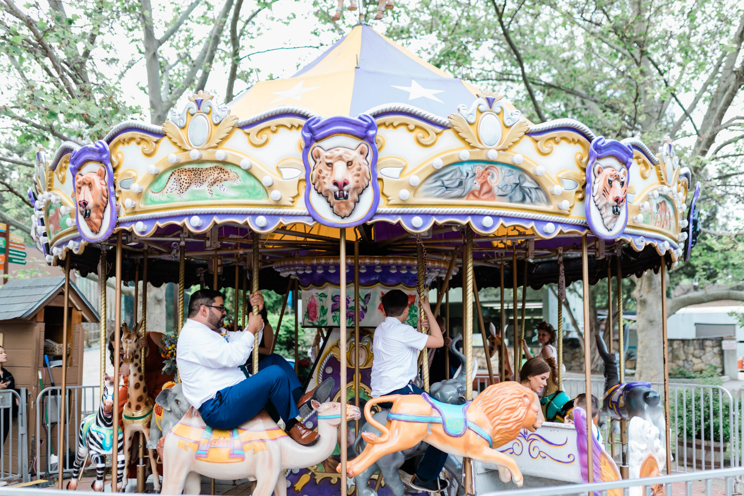 wedding guests riding carousel after colorful wedding ceremony