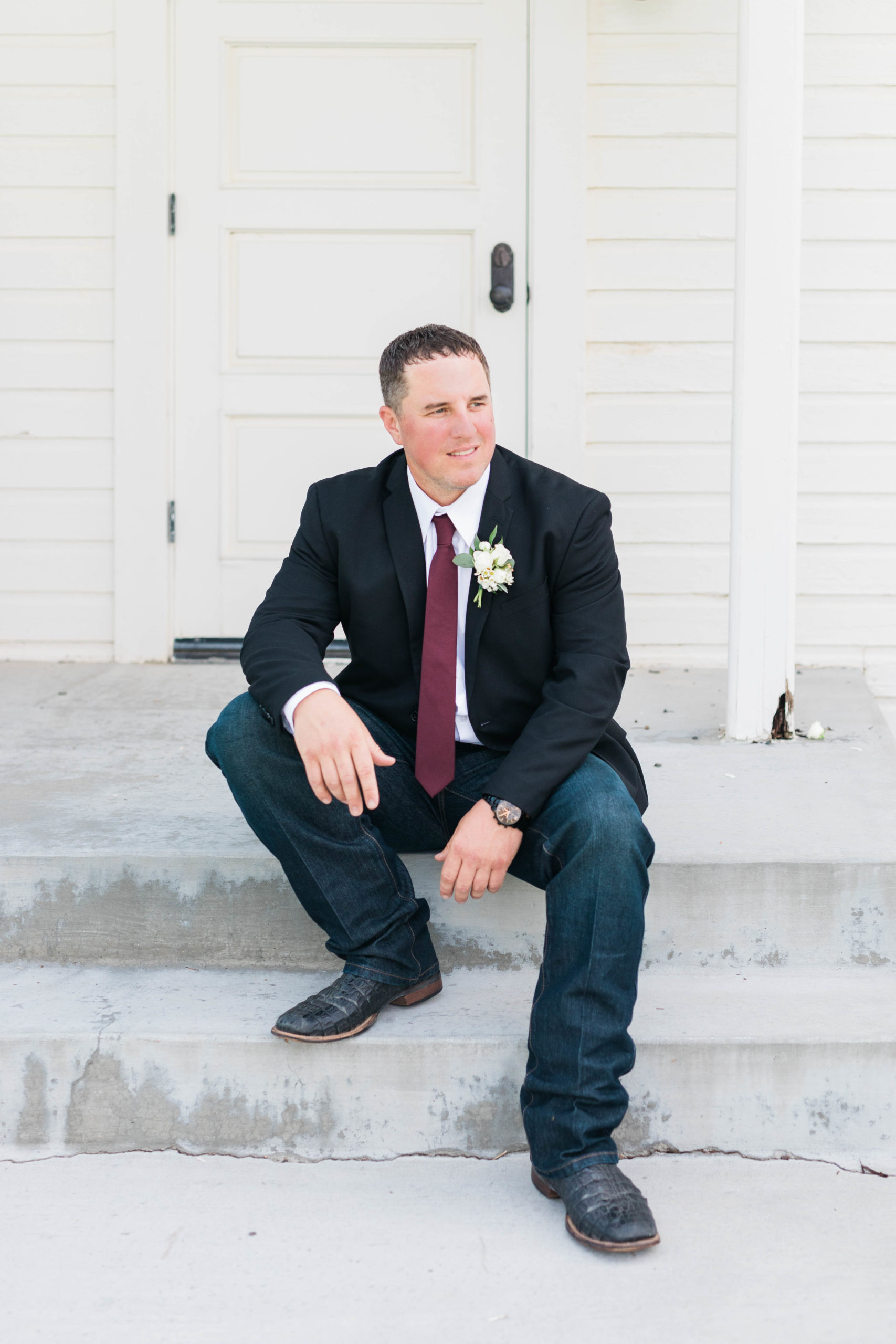Boise wedding photographer captures groom wearing blazer and dark denim jeans