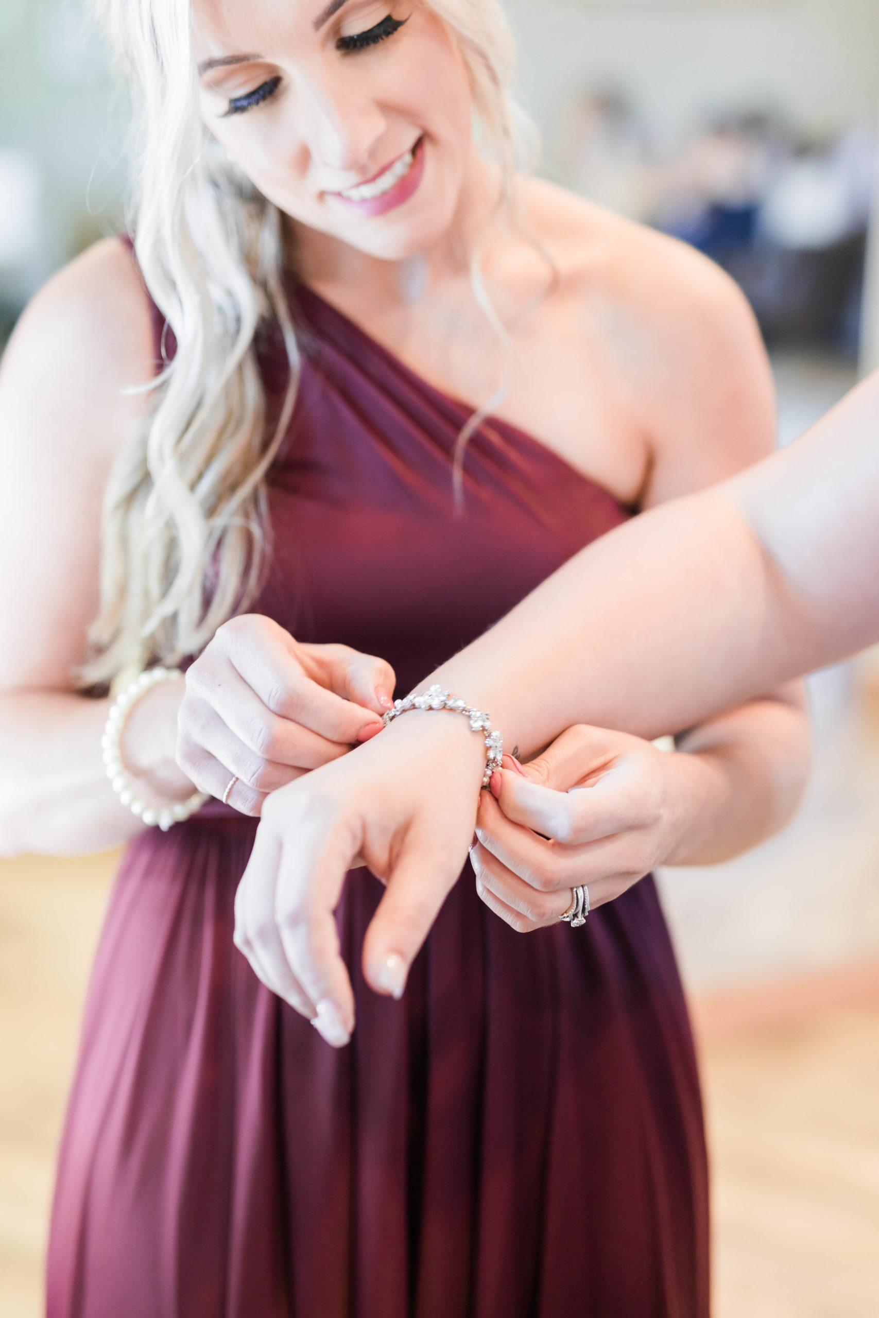 bridesmaid putting on bride's bracelet