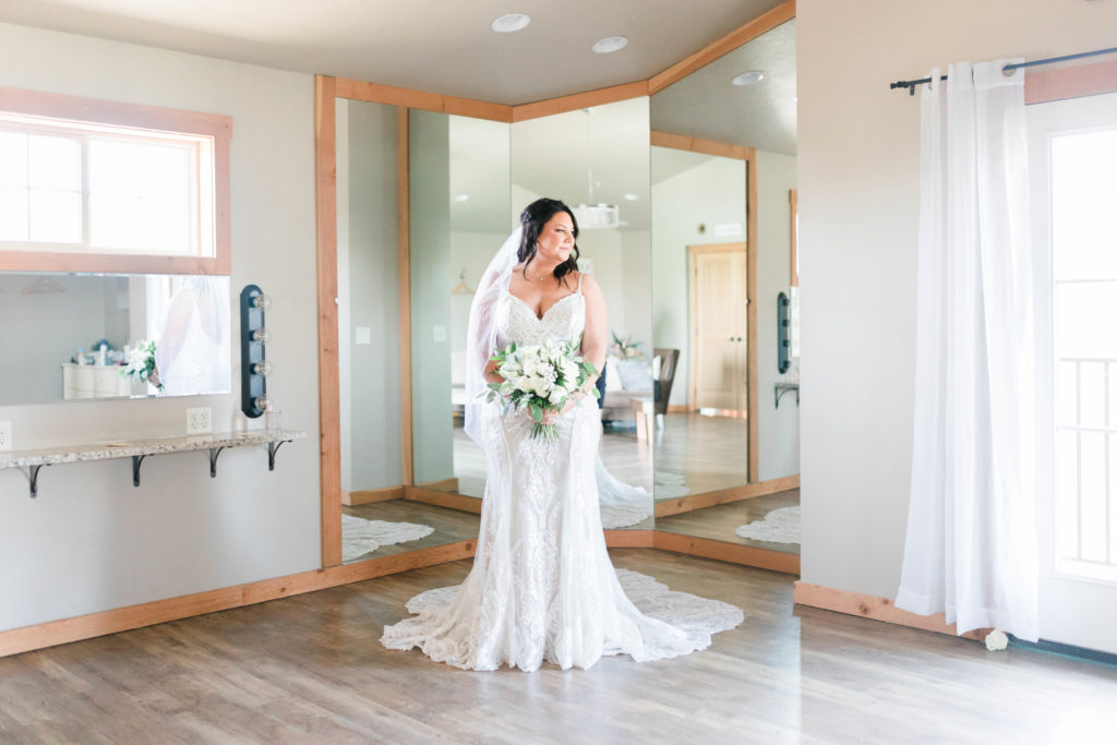 Boise wedding photographer captures bride holding bouquet with wedding dress and bouquet