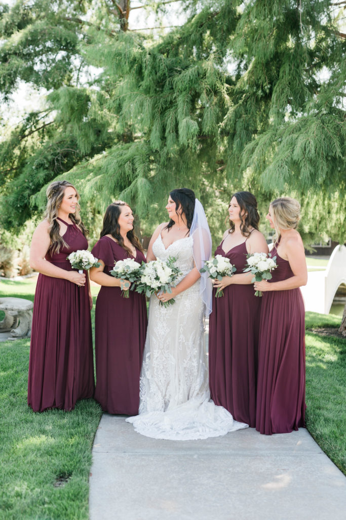 Idaho wedding photographer captures bride standing with bridesmaids before still water hollow wedding
