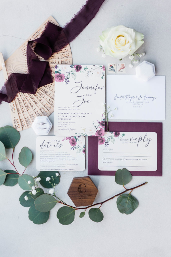 wedding details with invitations, ribbons, and eucalyptus 