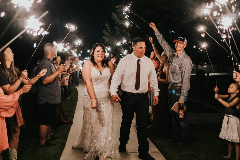 bride and groom exiting wedding reception during sparkler exit