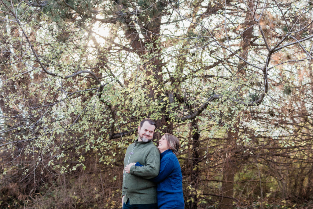 Boise wedding photographer captures couple hugging outside forest 