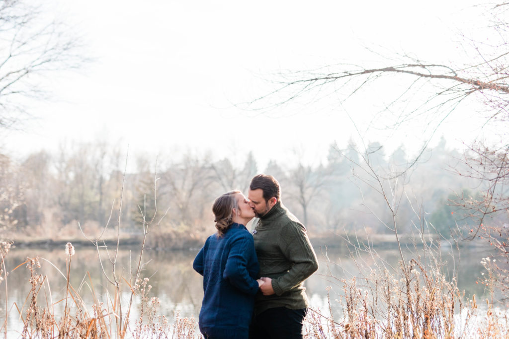 Boise wedding photographer captures newly engaged couple kissing wearing fall engagement outfits