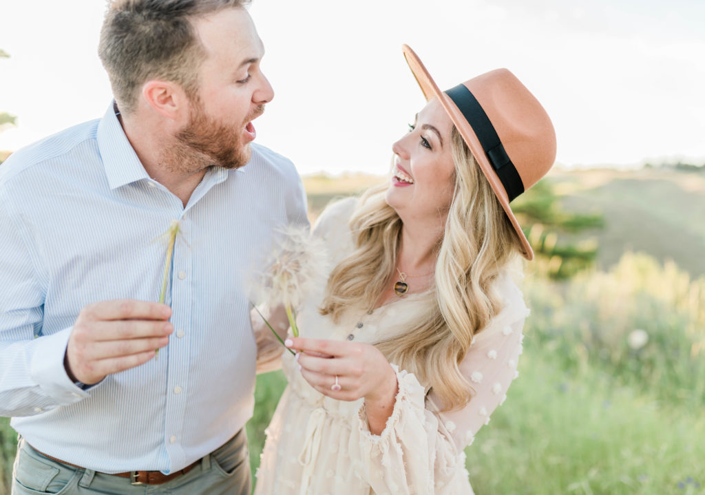 Boise wedding photographer captures couple holding dandelions and making a wish
