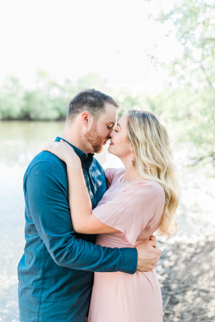 couple kissing during joyful engagement photos