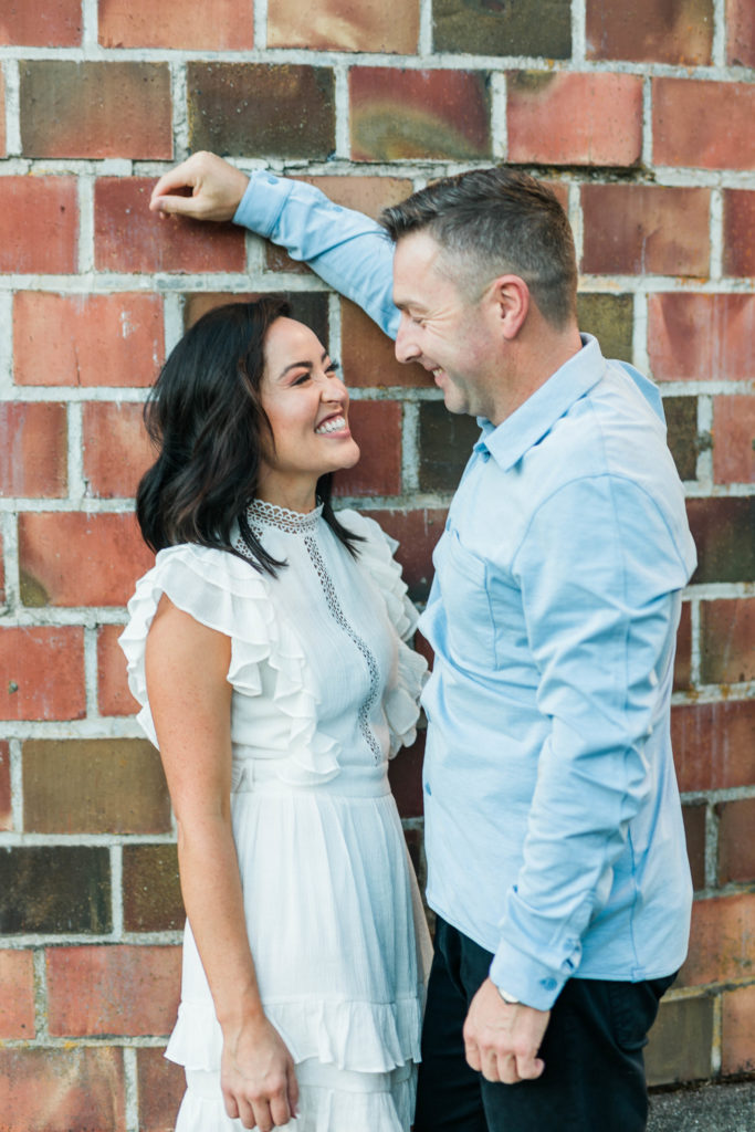 Boise wedding photographer captures couple leaning against brick wall