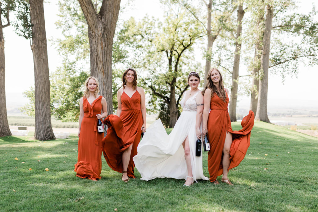 bride posing with bridesmaids wearing boho mismatched bridesmaid dresses