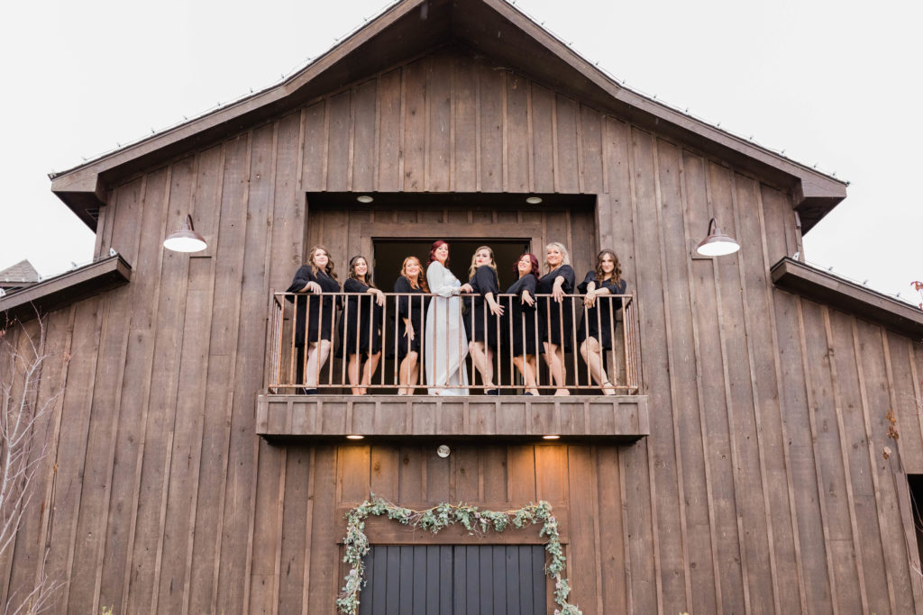 Boise wedding photographers capture bride and bridesmaids in balcony at Still Water Hollow wedding