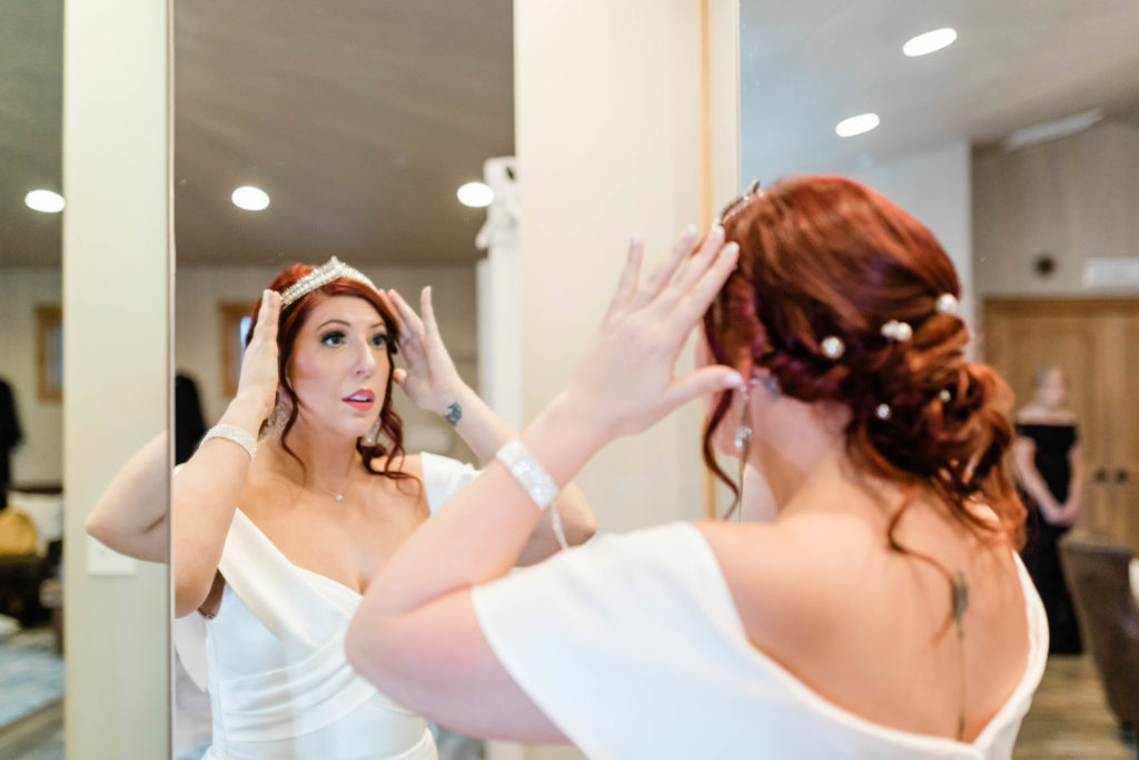 Boise wedding photographers capture bride putting on tiara before Still Water Hollow wedding ceremony
