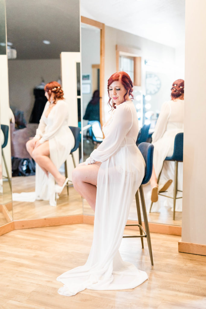 Boise wedding photographers capture bride in white robe getting ready for Boise wedding