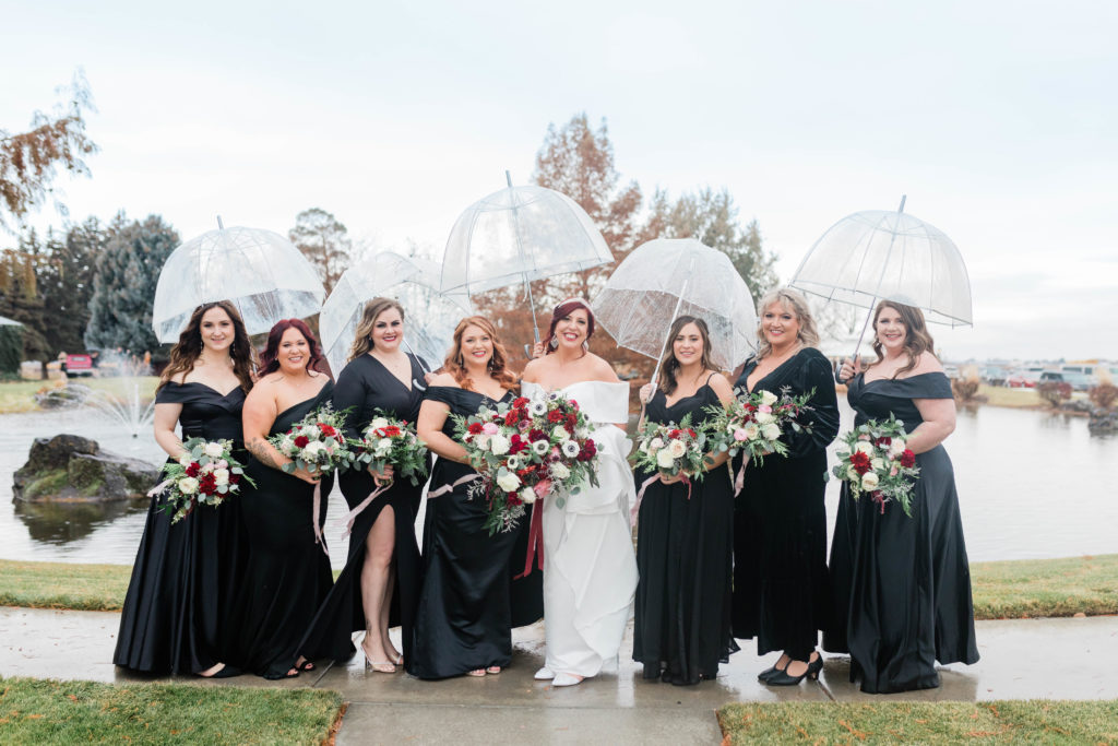 Boise wedding photographers capture bride with bridesmaids during rainy wedding day portraits at Still Water Hollow wedding