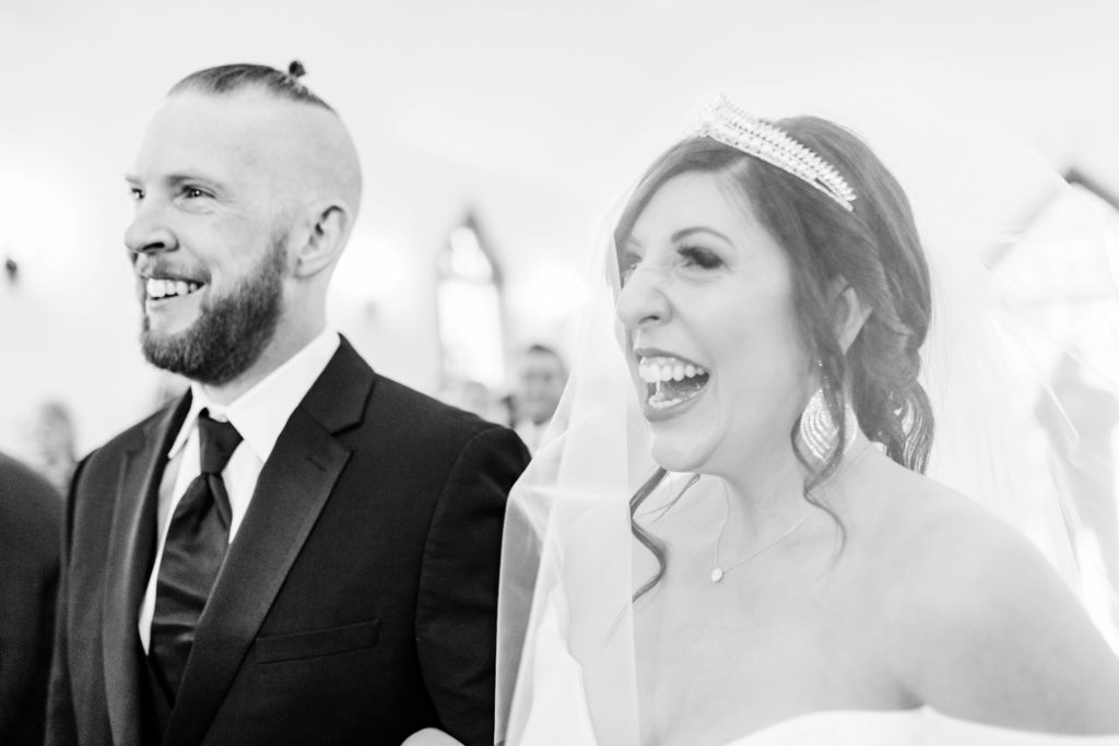 Boise wedding photographer captures bride smiling and laughing as she walks down aisle