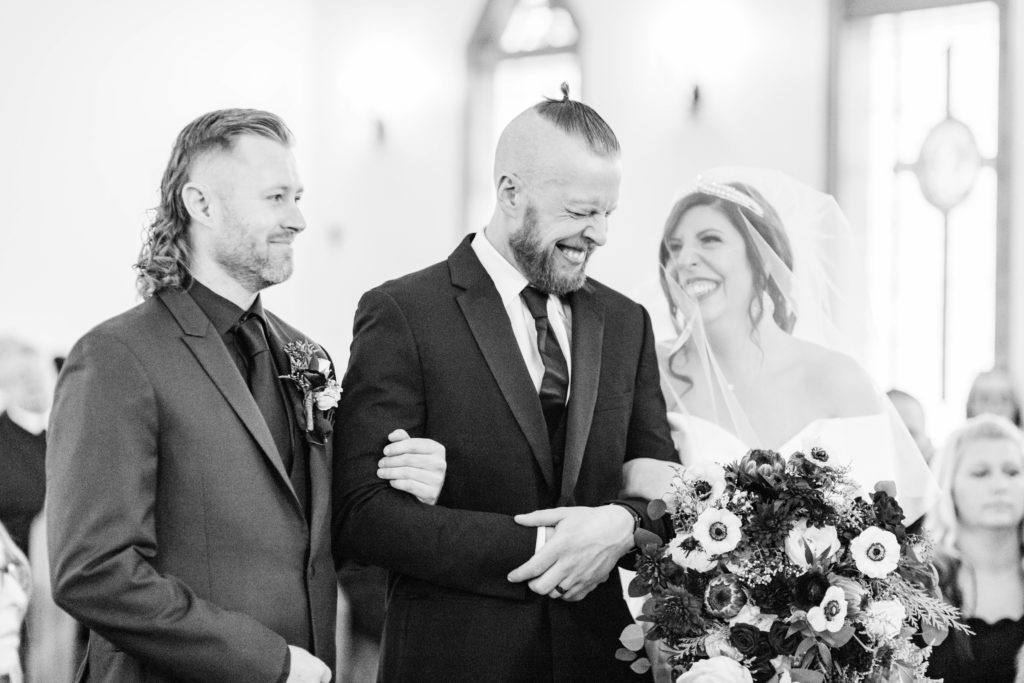 Boise wedding photographers capture groom taking bride from family walking down aisle