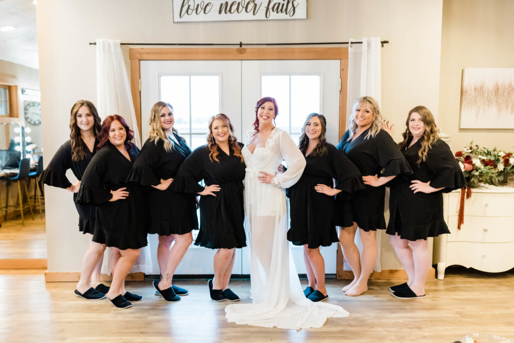 Boise wedding photographers capture bride standing with bridesmaids wearing matching robes before Boise wedding