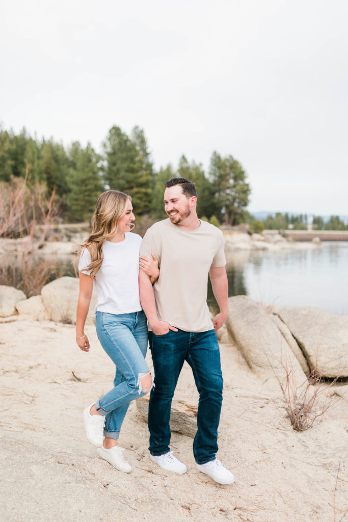 Boise wedding photographer captures newly engaged couple walking wearing neutral engagement outfits
