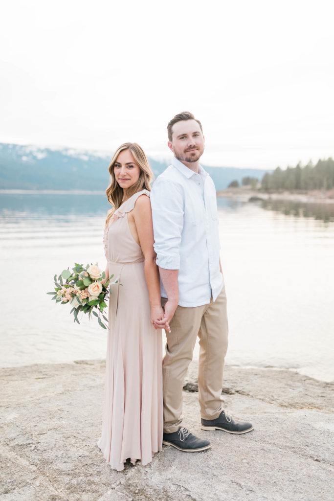 Man and woman holding hands in formal engagement outfits during cascade lake engagement session