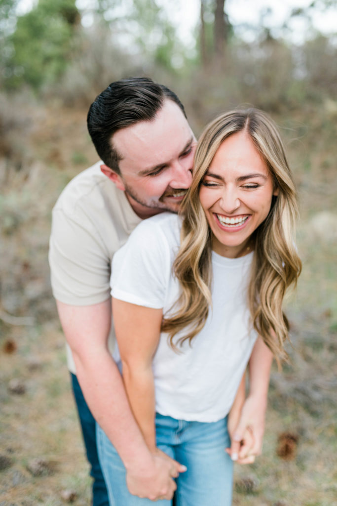 Boise wedding photographers captures couple embracing and laughing together during engagement session