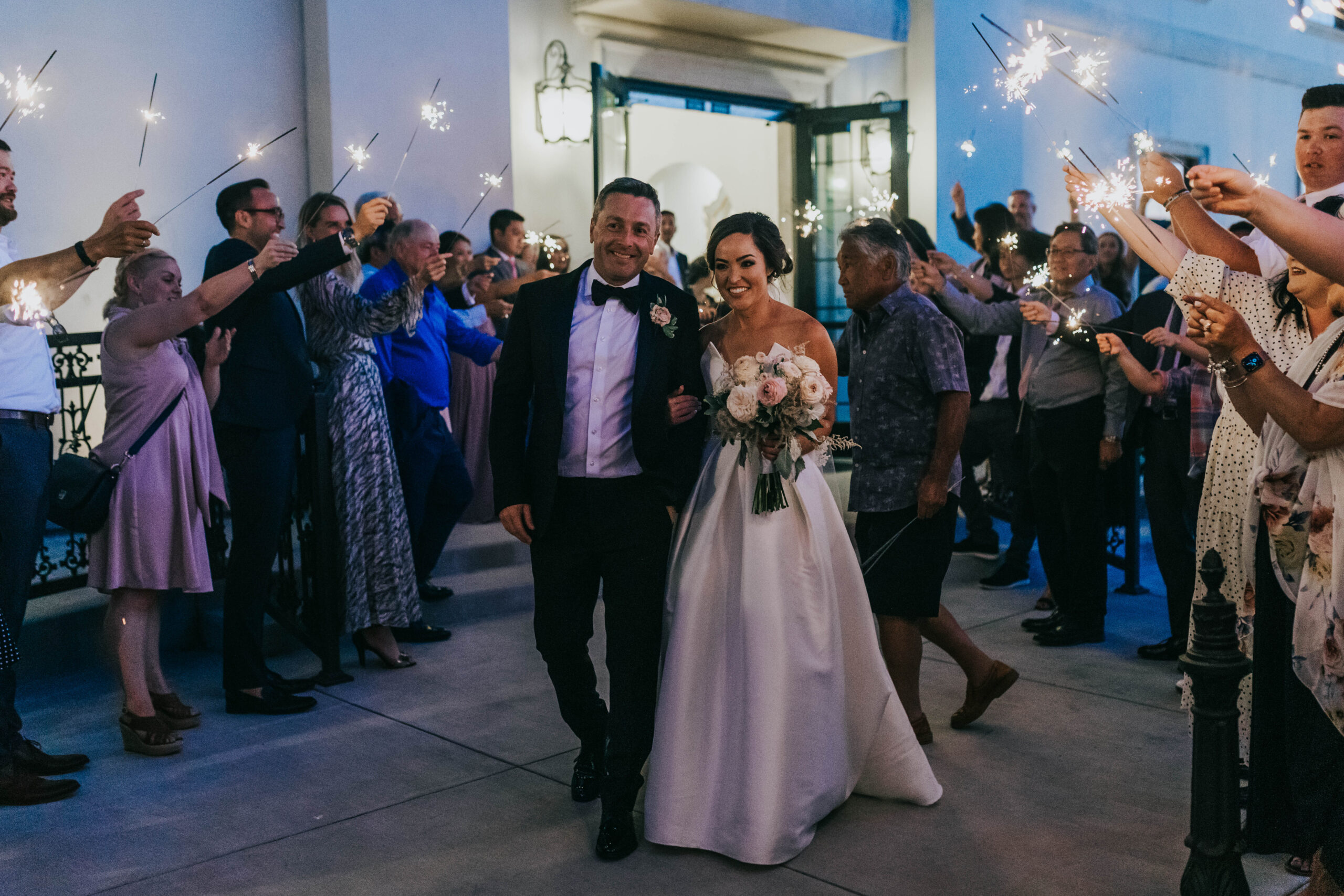Boise wedding photographers capture couple leaving wedding together during sparkler exit