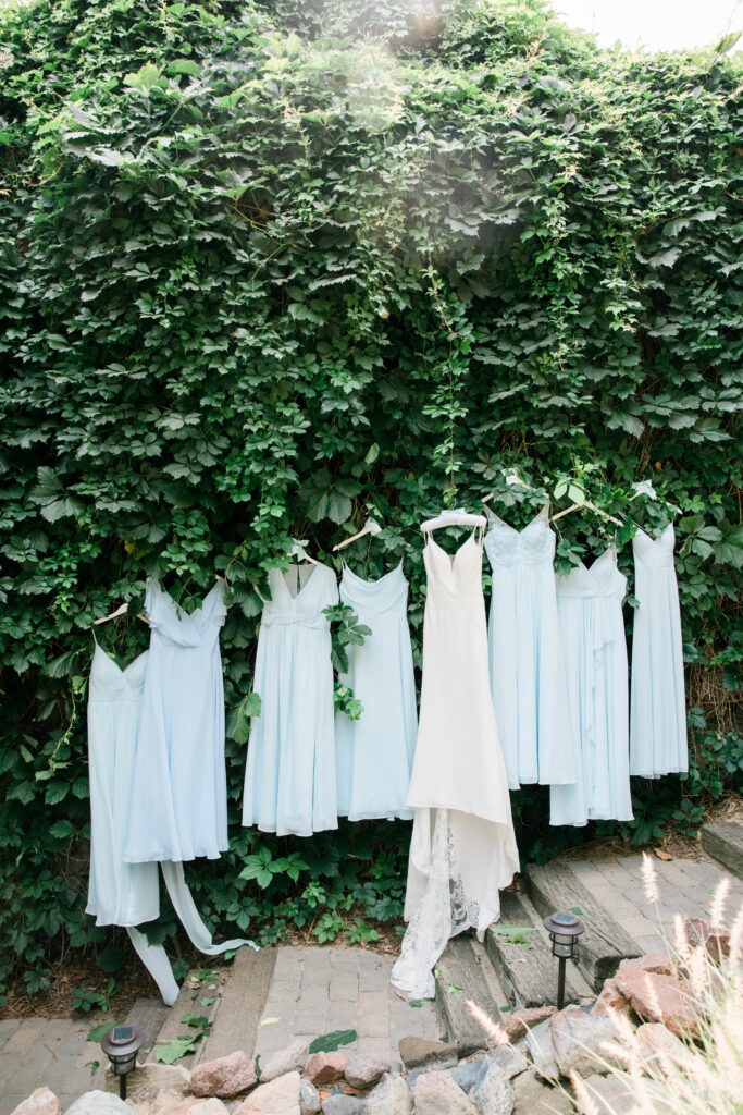 Boise wedding photographers captures bridal gown and blue bridesmaids gowns hanging