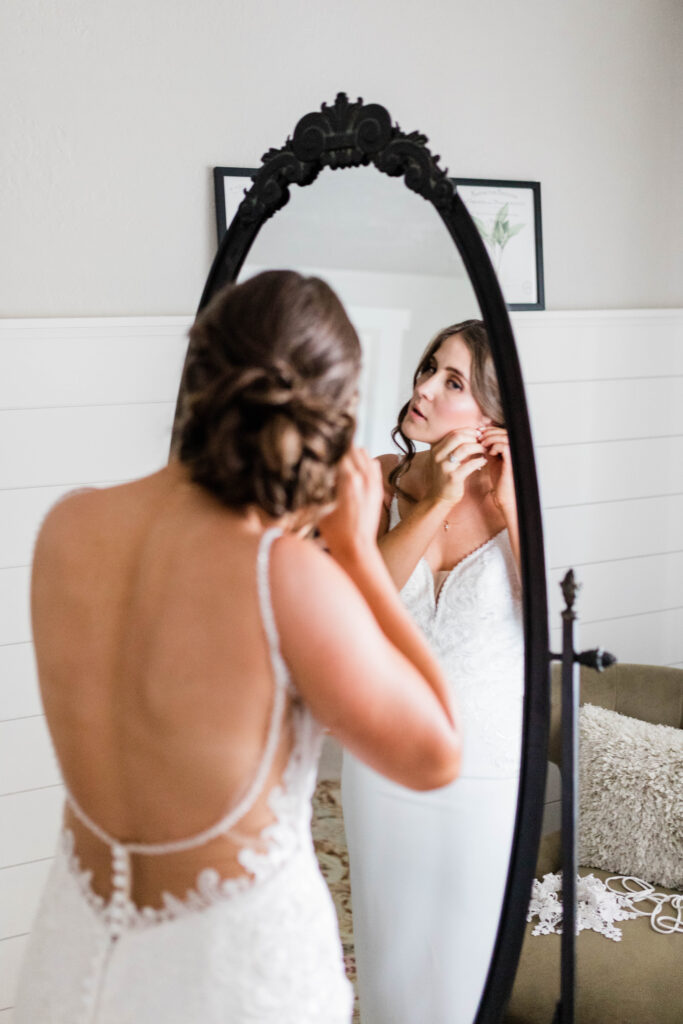 Boise wedding photographers capture bride putting earrings on before wedding