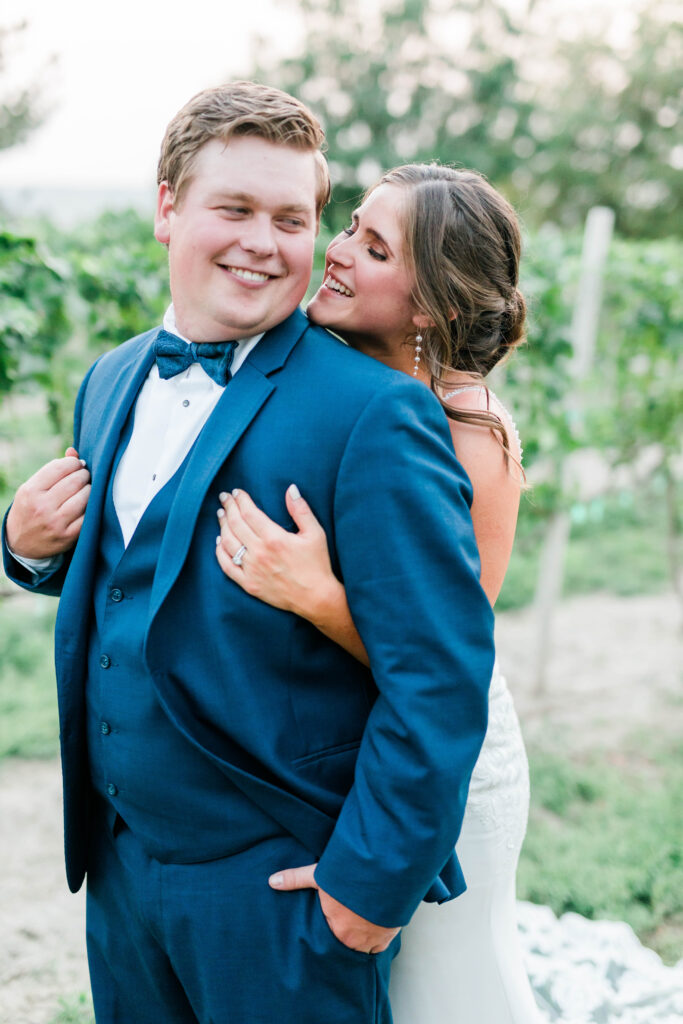 Boise wedding photographer captures couple hugging in vineyard after outdoor ceremony