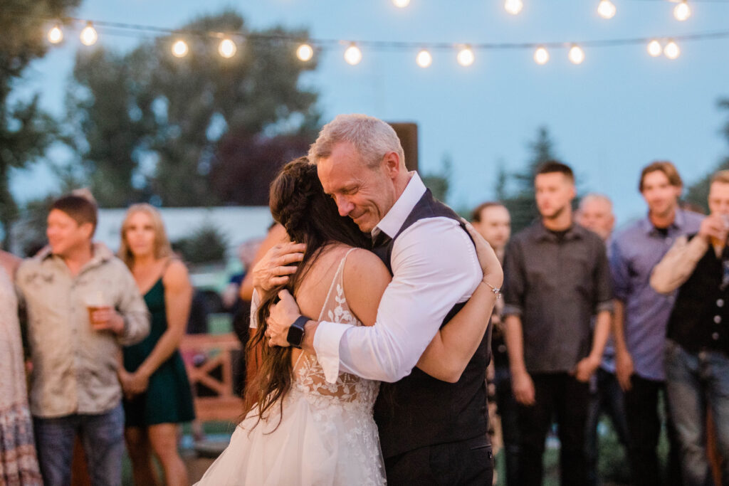 Boise wedding photographer captures bride hugging father after father daughter dance