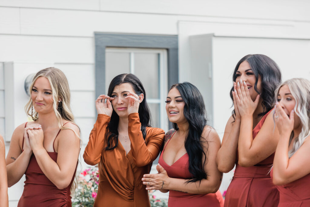 close up of bridesmaids crying after seeing bride for first time in wedding gown