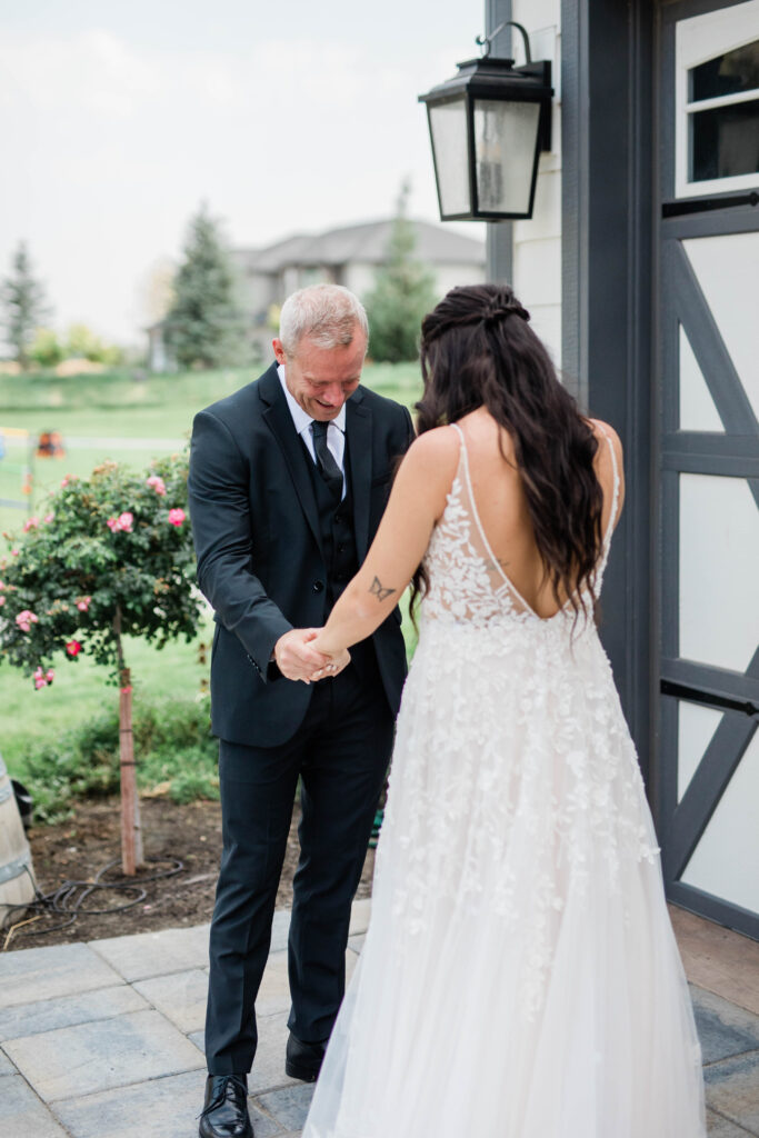 Boise wedding photographer captures bride holding father's hands during first look