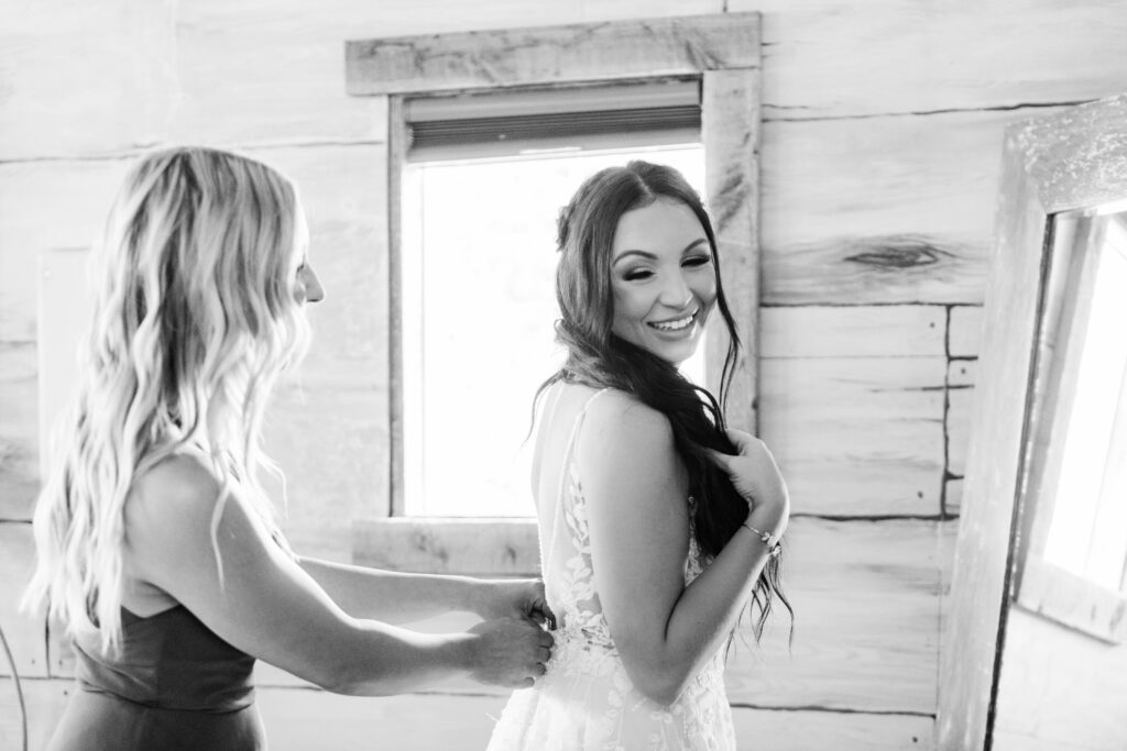 Boise wedding photographer captures black and white portrait of bride getting wedding dress on