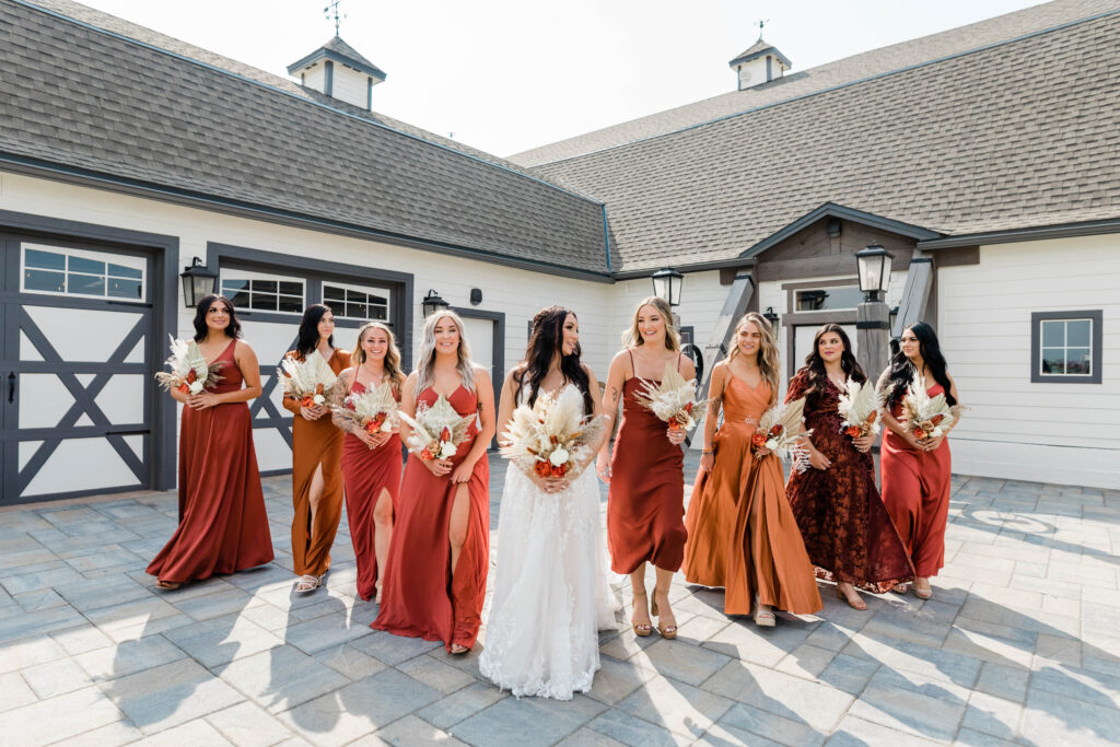 Boise wedding photographer captures bride with bridesmaids wearing mismatched gowns