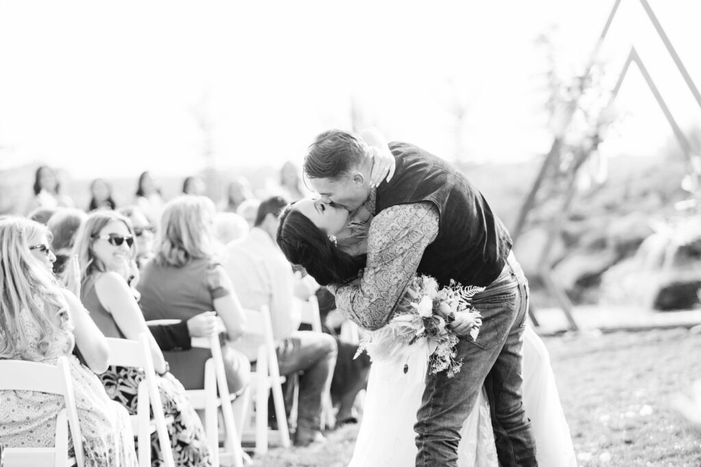 Boise wedding photographer captures bride and groom kissing after wedding ceremony