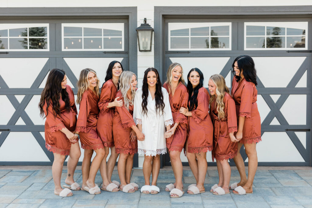 bride standing with bridesmaids wearing burnt orange robe
