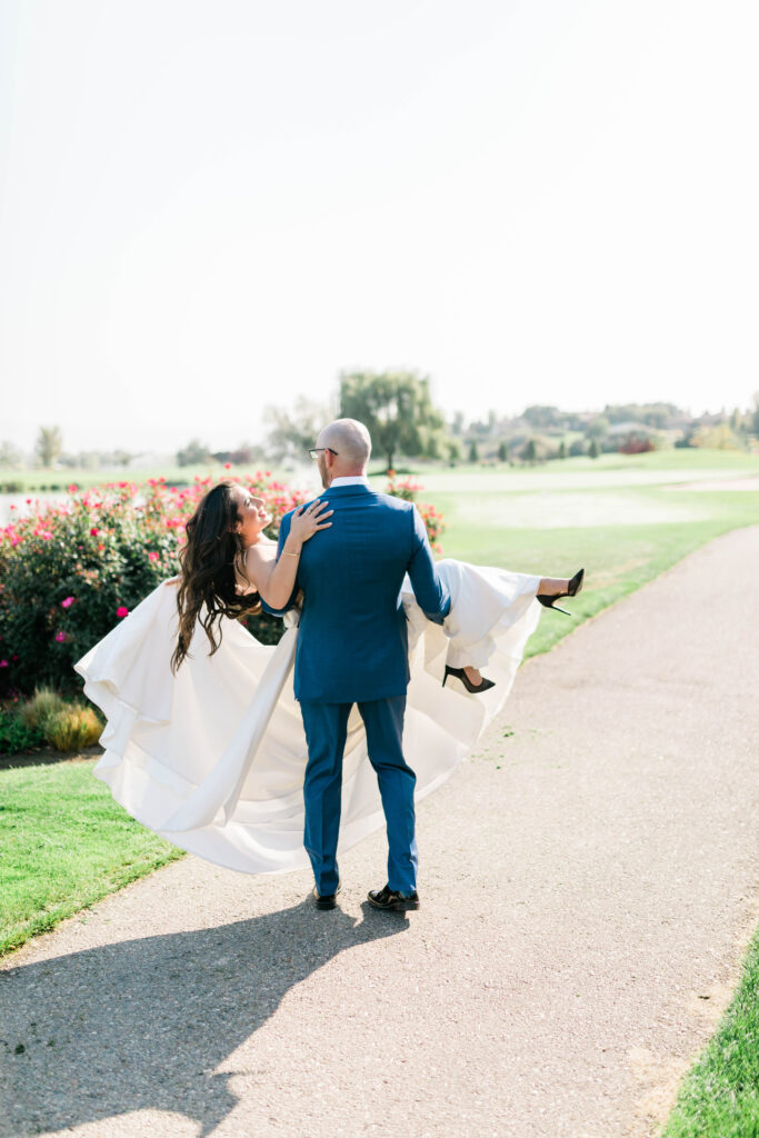 Boise wedding photographer captures groom carrying bride 
