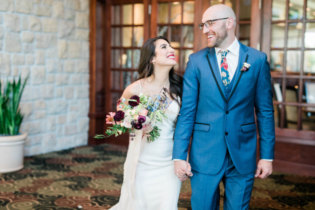 Boise wedding photographer captures bride and groom walking hand in hand at Boise wedding venue