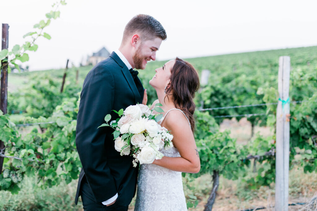 Boise wedding photographer captures couple looking at one another in vineyards