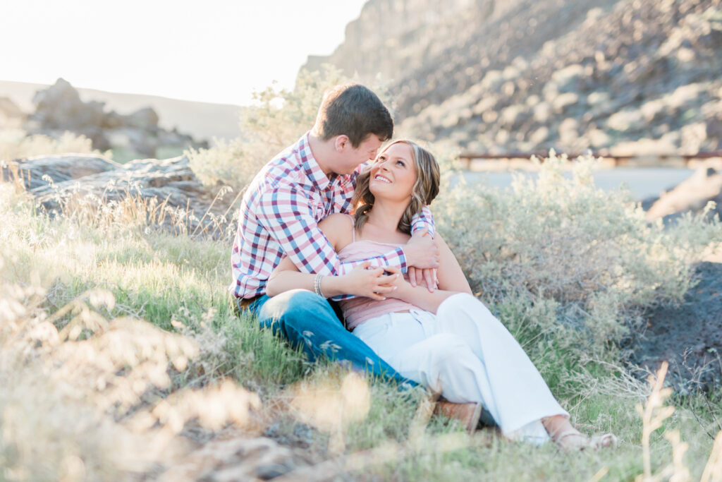 Boise wedding photographer captures couple sitting in grass together