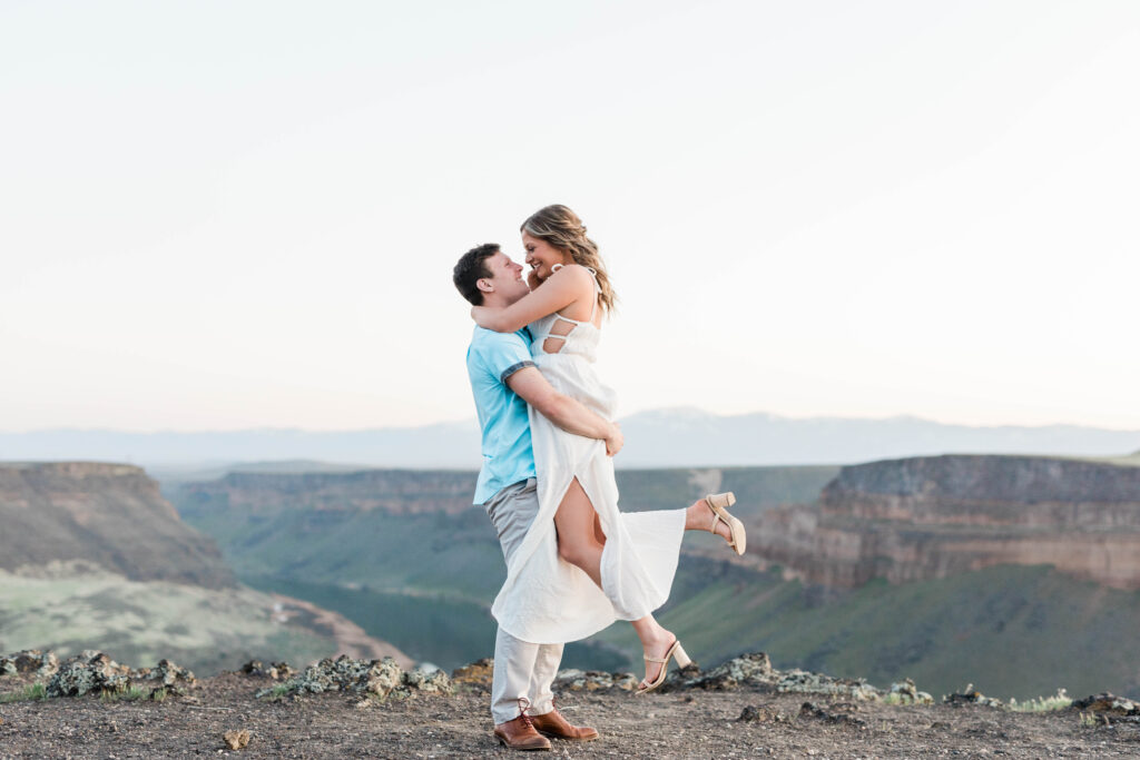 Boise wedding photographer captures man lifting woman during swan falls engagements