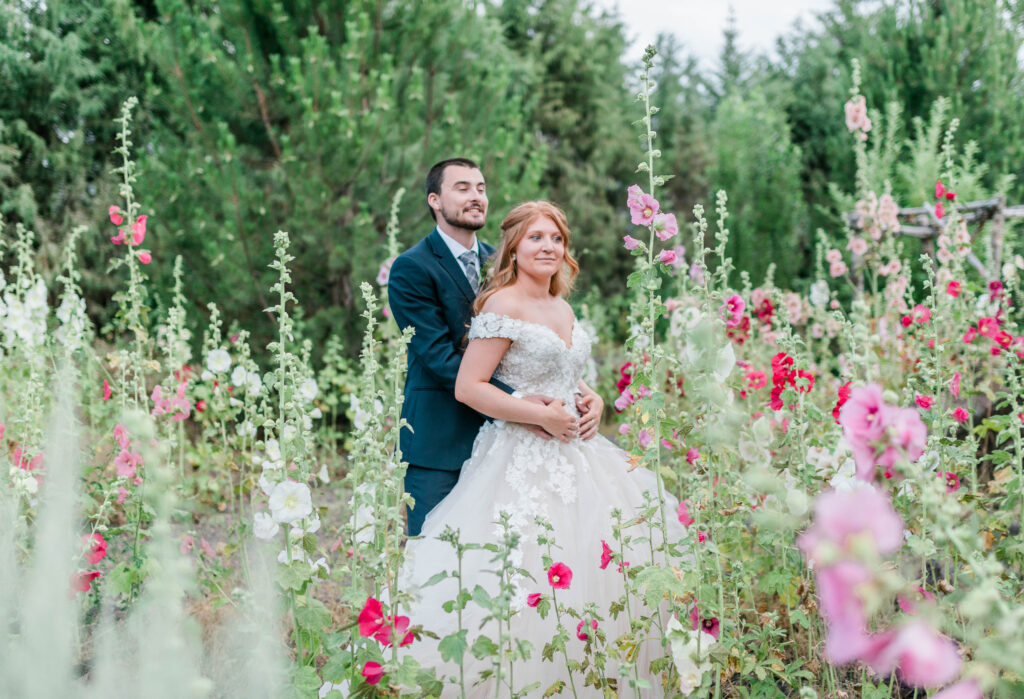 Boise wedding photographer captures couple in field of wildflowers on wedding day after rainy day wedding planning